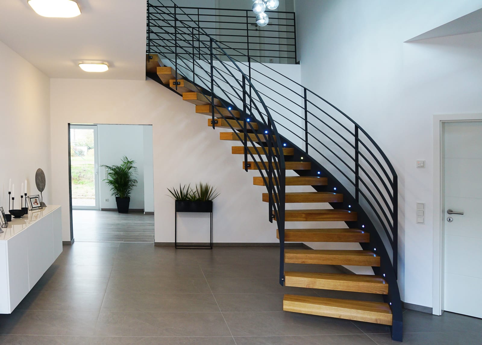 Schwebende Kragarmtreppe mit schwarzem Stahlgeländer in modernem Wohnhaus - Treppenbauprojekt