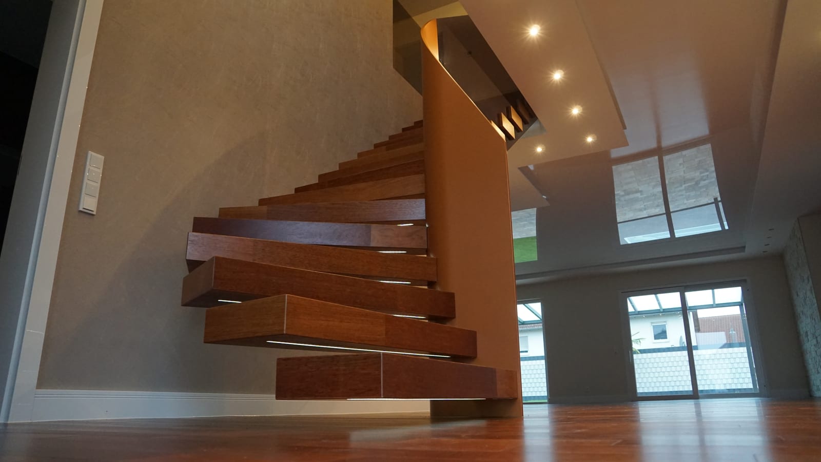 Kragarmtreppe mit Kirschholzstufen und Edelstahlgeländer - warme Holzoptik trifft modernes Design