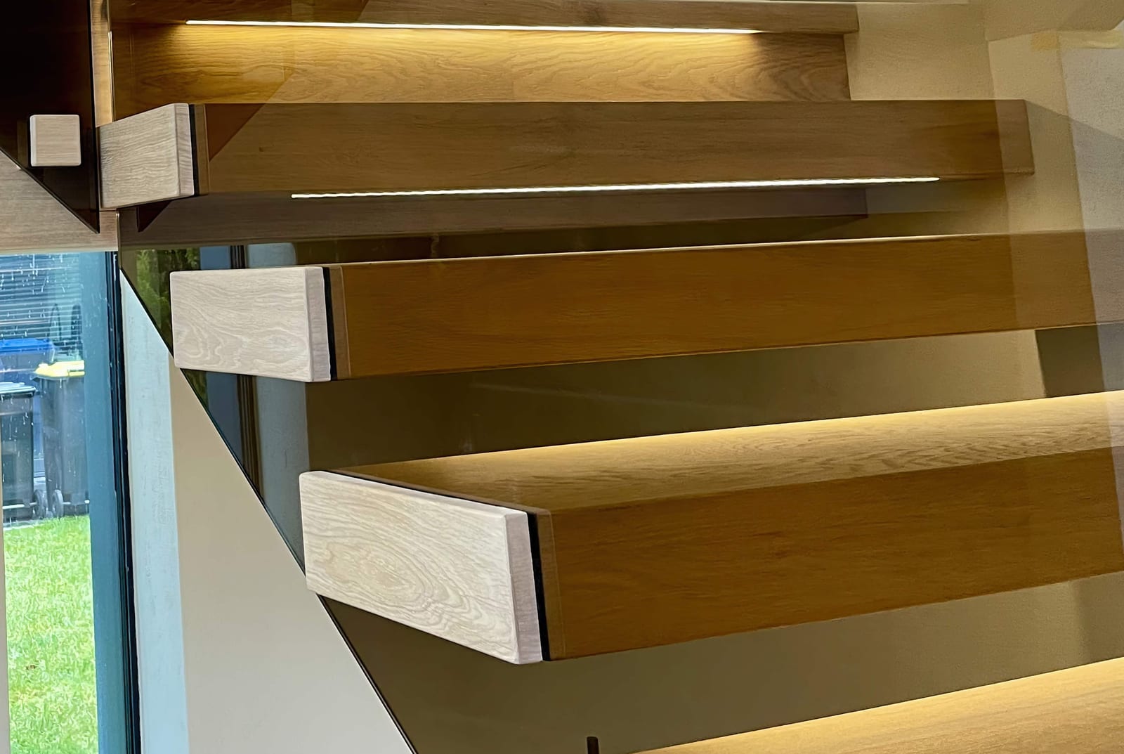 Kragarmtreppe Eiche von unten mit durchlaufendem LED-Lichtband – AN Treppenbau