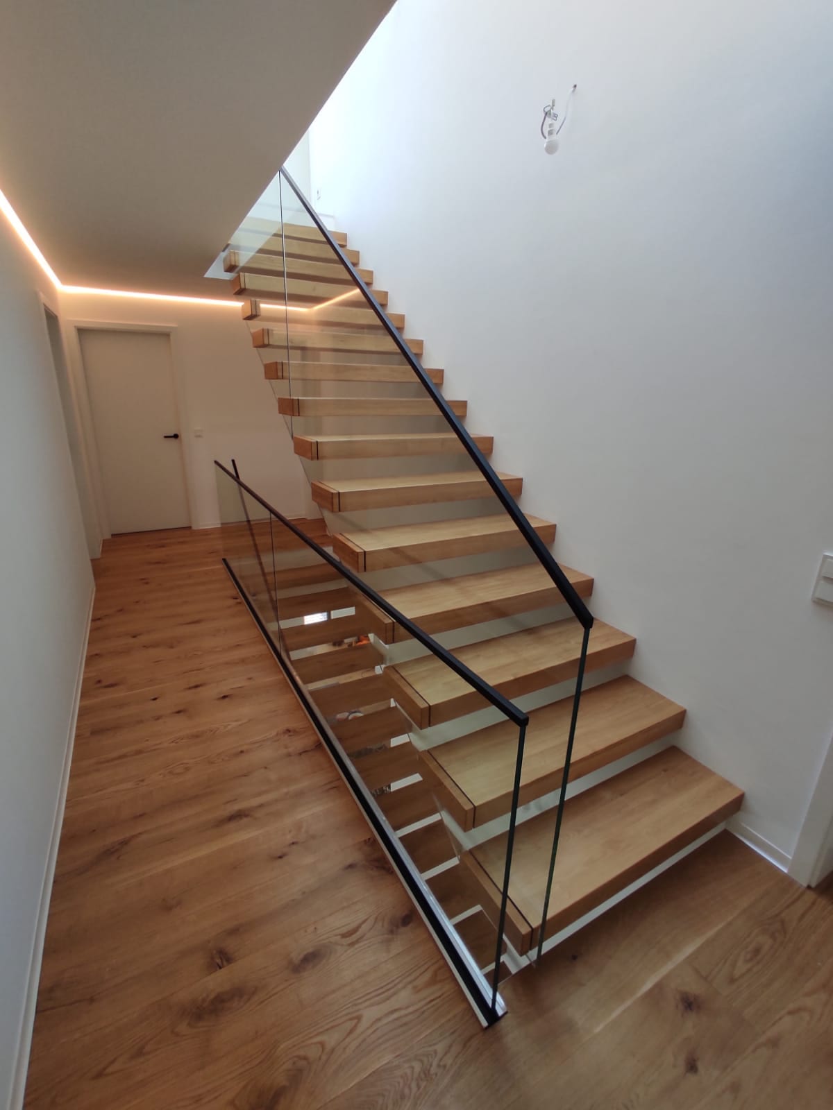 Kragarmtreppe Eiche mit Glasgeländer und schwarzem Handlauf – AN Treppenbau