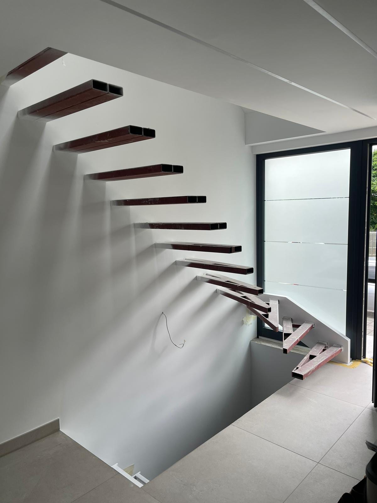 Kragarmtreppe mit Holzstufen an weißer Wand, Blick von der Galerie nach unten – AN Treppenbau
