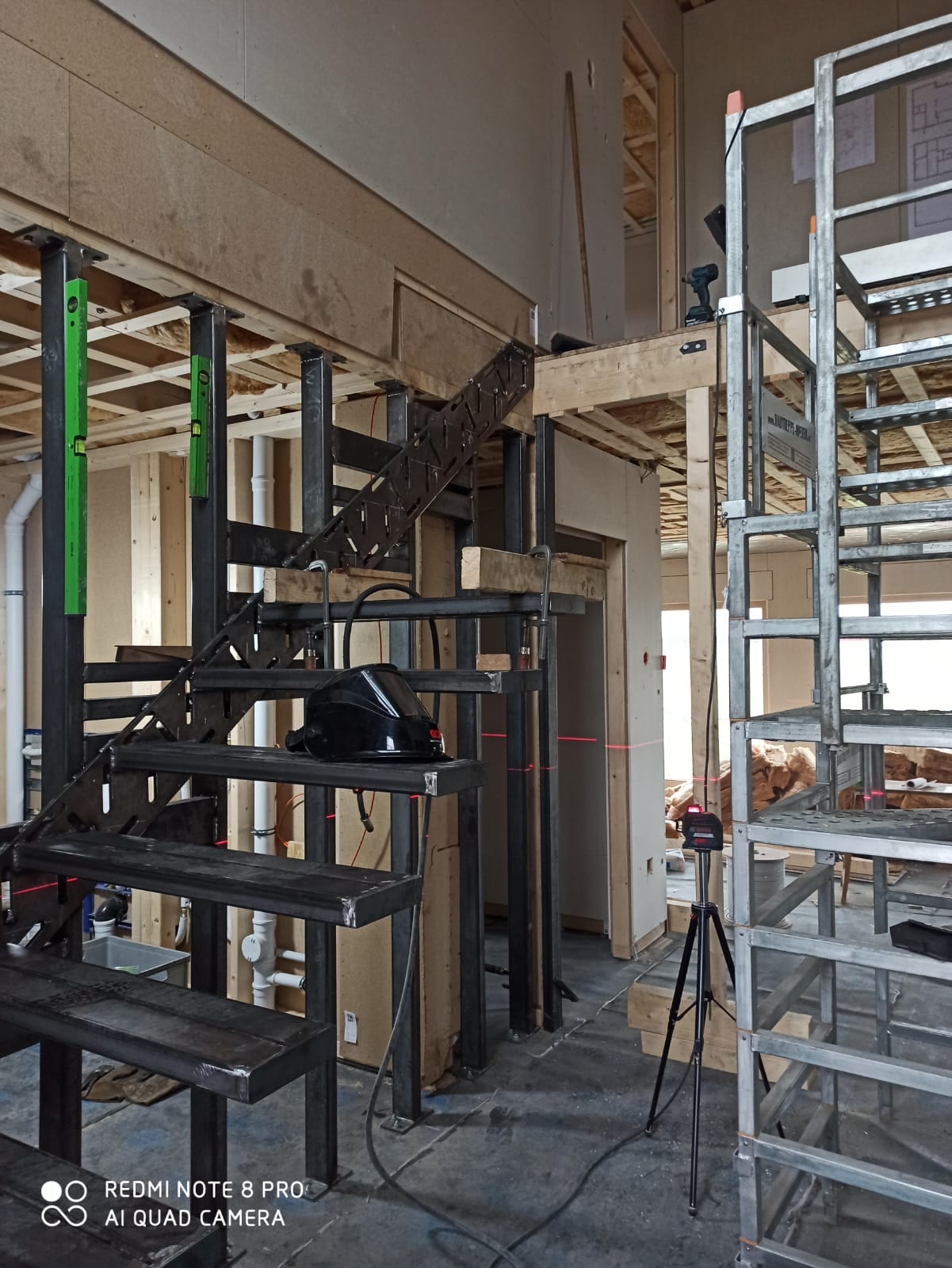 Schwarze Stahlunterkonstruktion einer gewendelten Kragarmtreppe im Rohbau, Montage vom Gerüst – AN Treppenbau