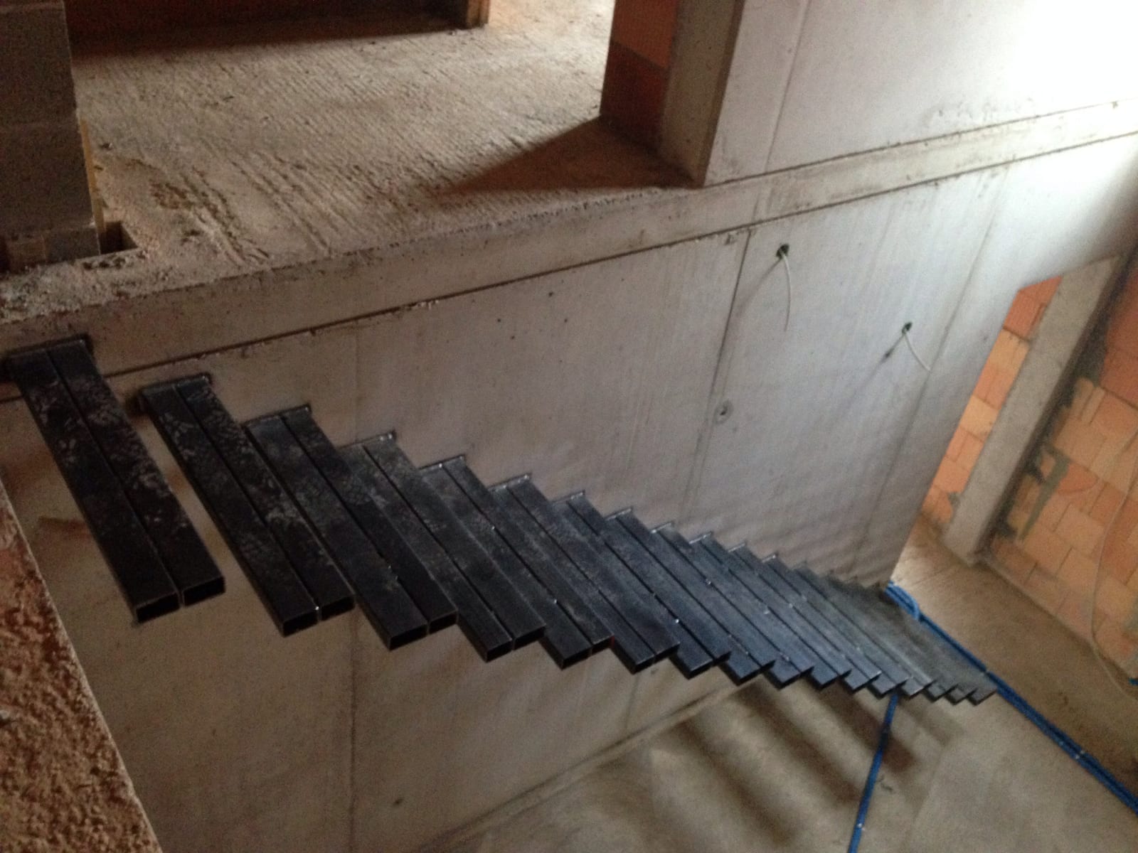 Kragarme aus Stahl an der Betonwand verankert, Rohbau – AN Treppenbau