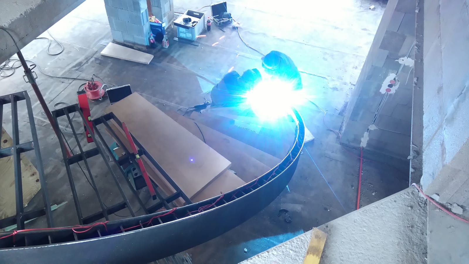 Schweißarbeiten an einer gebogenen Tragkonstruktion in der Werkstatt – AN Treppenbau
