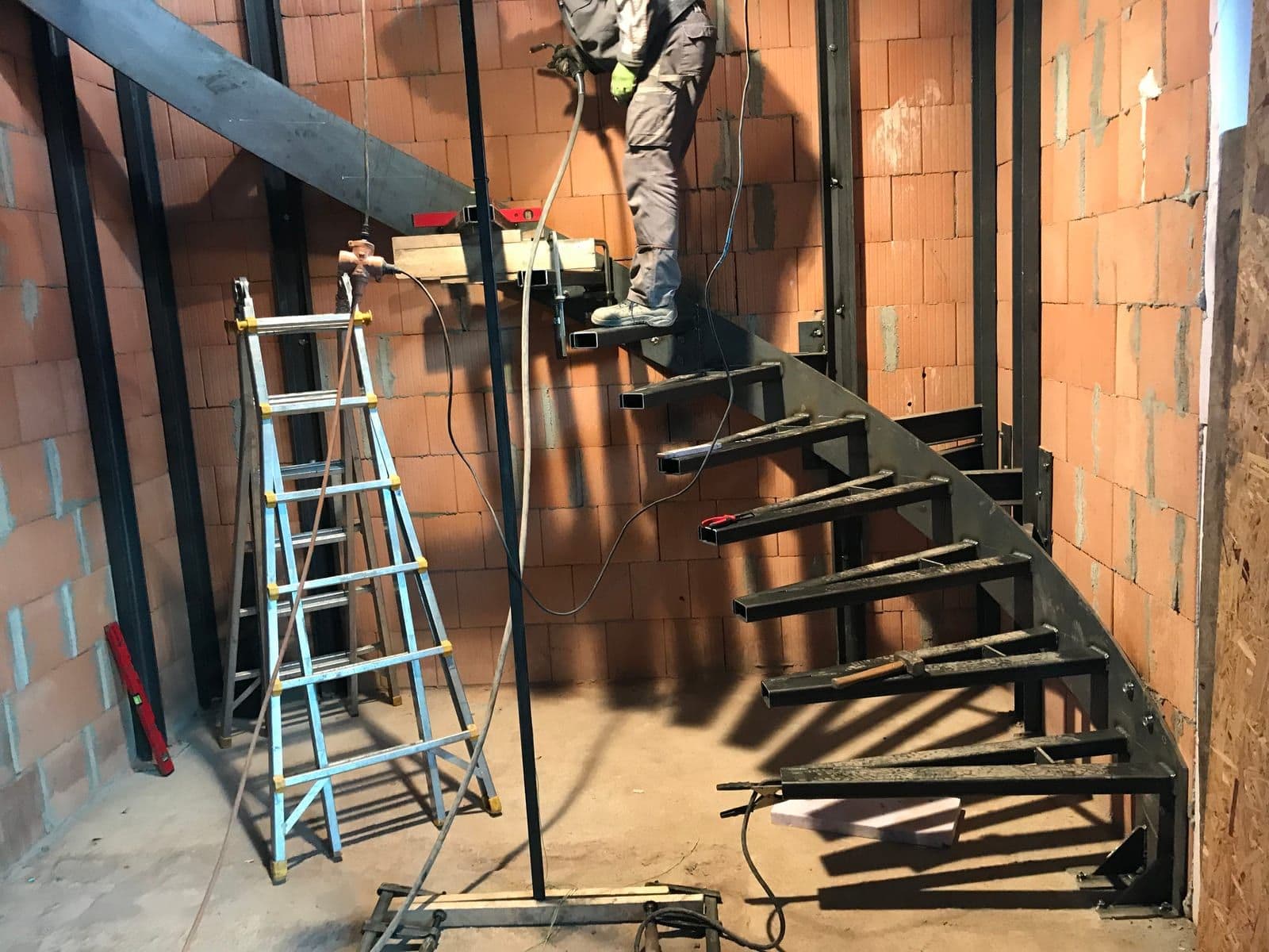 Montage der Unterkonstruktion an einer Ziegelwand, gewendelter Lauf – AN Treppenbau