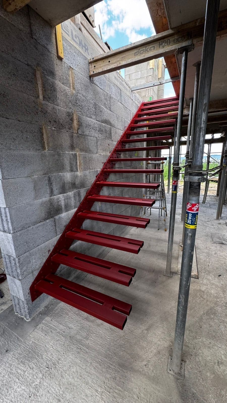 Rot grundierte Kragarme an einer Mauerwerkswand – AN Treppenbau