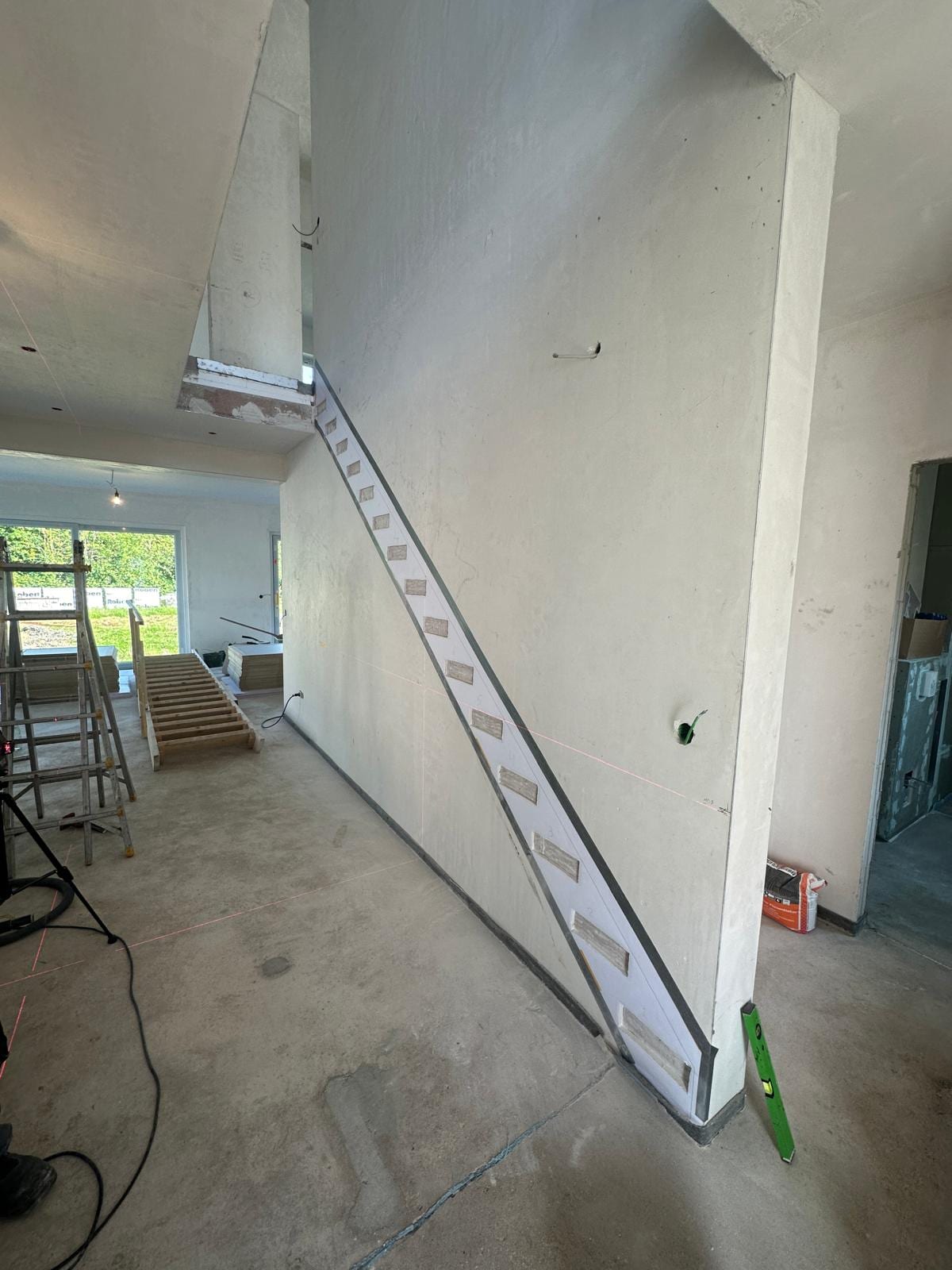 Montage einer Kragarmtreppe im Rohbau: Stahl-Unterkonstruktion mit Konsolen an der Wand befestigt