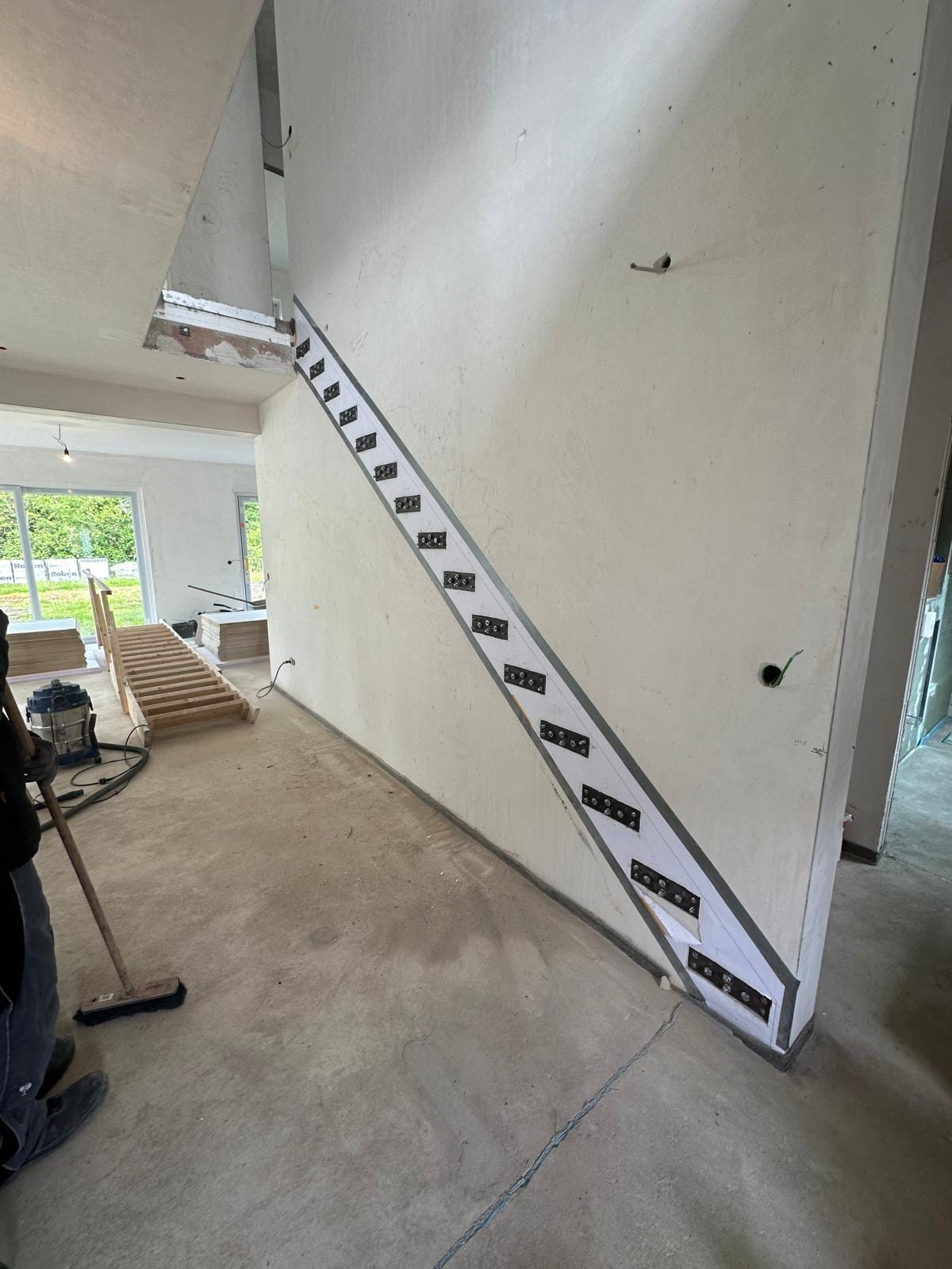 Stahlkonsolen der Kragarmtreppe an der Rohbauwand vor dem Einputzen, Blick aus dem Wohnraum