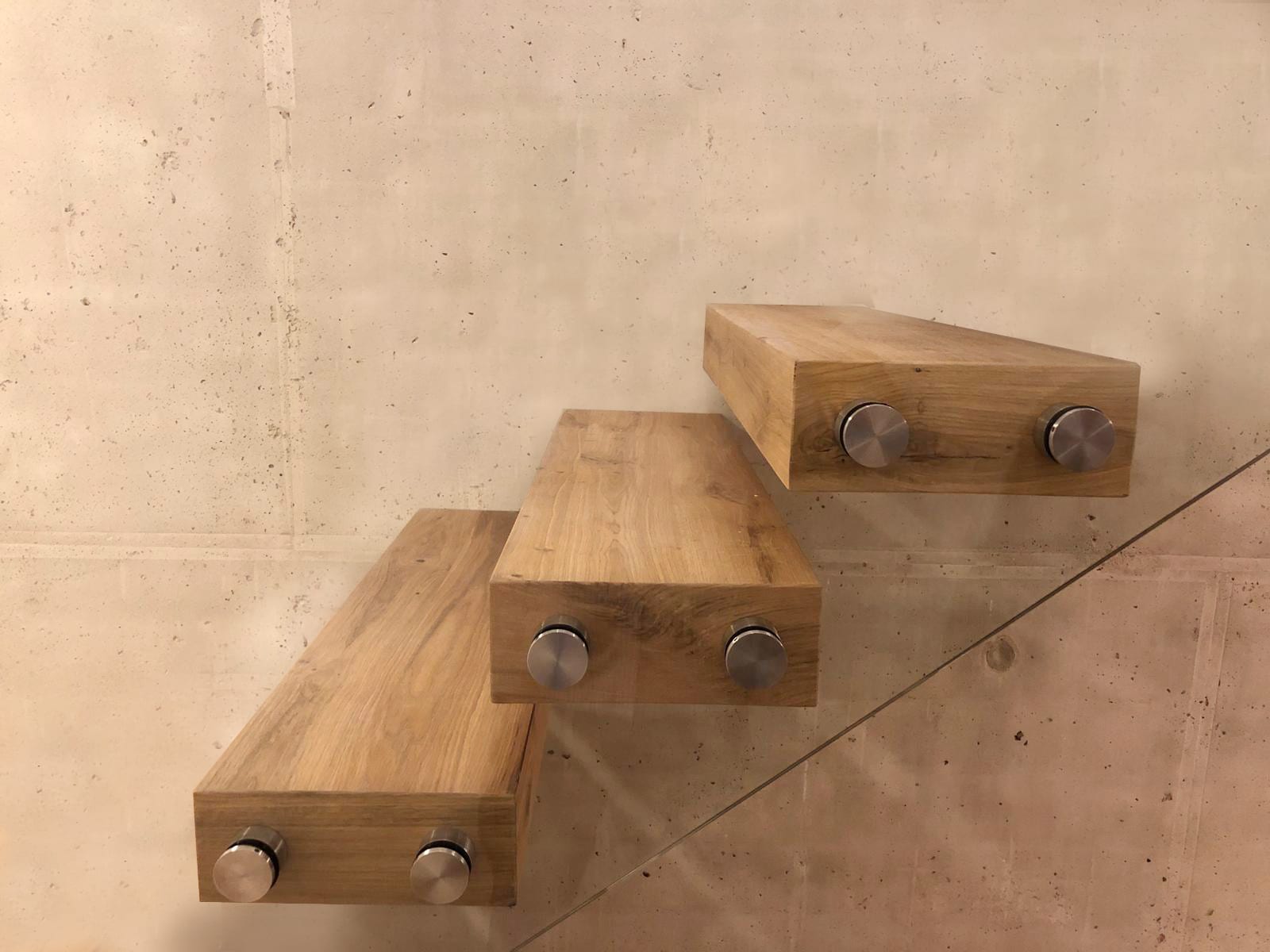Drei Kragarmstufen aus Eiche mit Edelstahl-Bolzen für ein Bolzengeländer, Detail an der Wand