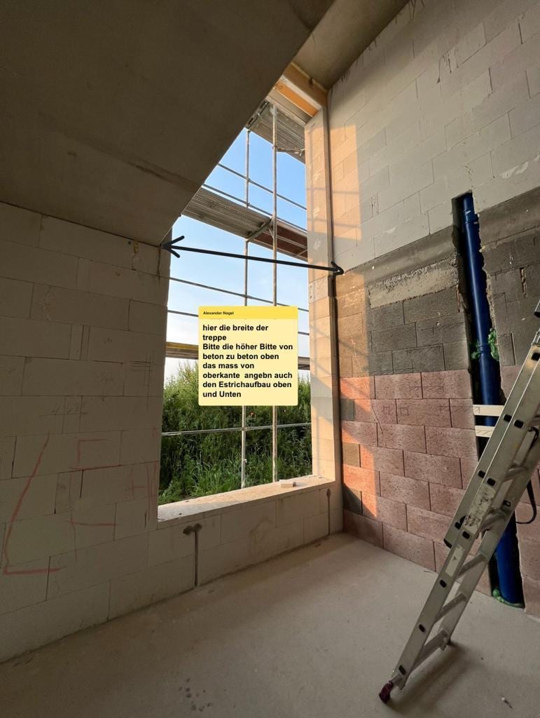 Rohbau mit Markierung für die Treppenbreite an der Wand, Hinweiszettel und Leiter