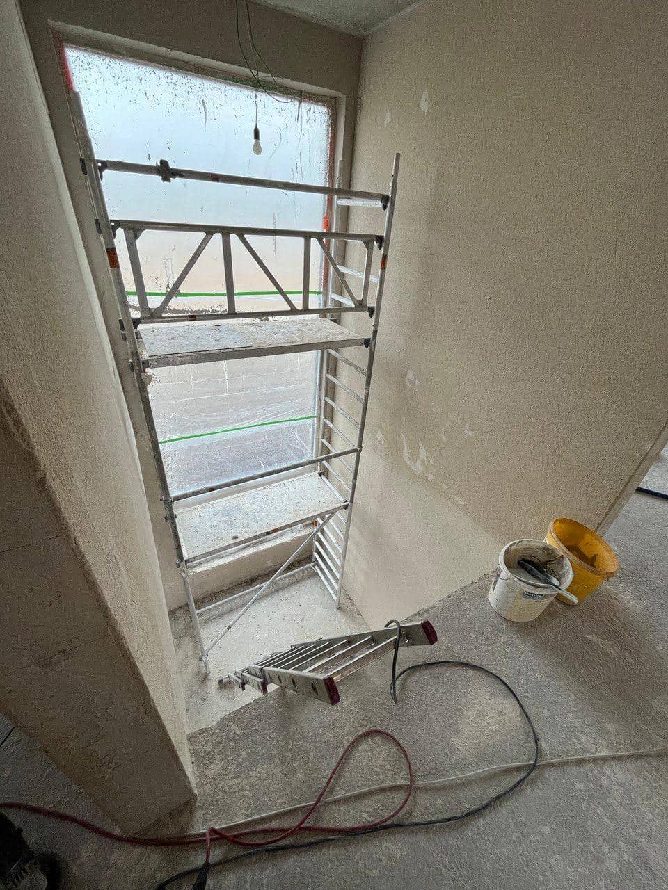 Rohbau-Treppenhaus mit Gerüst vor dem Fenster, Vorbereitung für die Kragarmtreppe