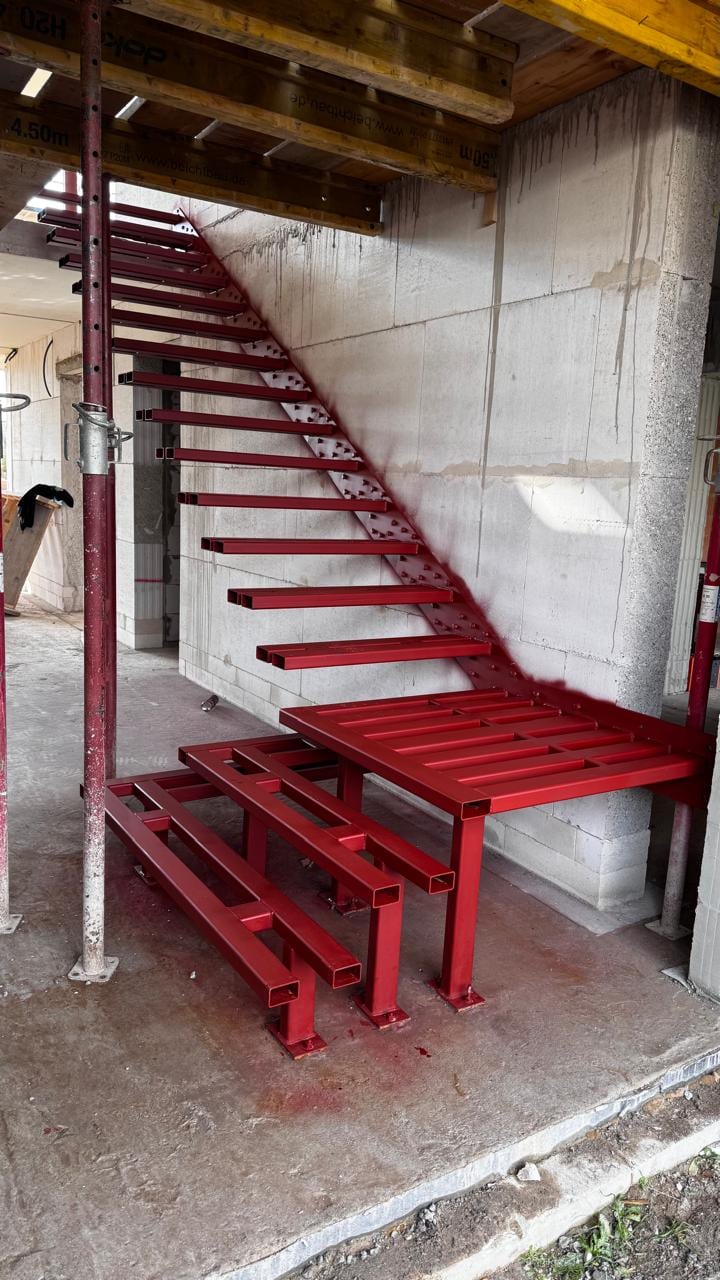 Rot grundierte Stahlunterkonstruktion mit Podest im Rohbau – AN Treppenbau