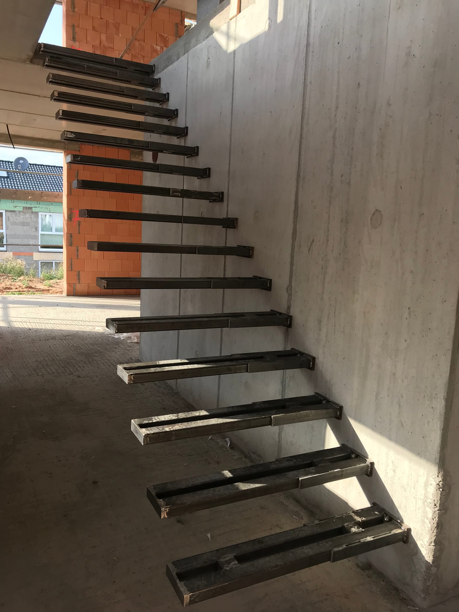 Kragarme an einer Sichtbetonwand, Unterkonstruktion vor dem Aufsetzen der Stufen – AN Treppenbau
