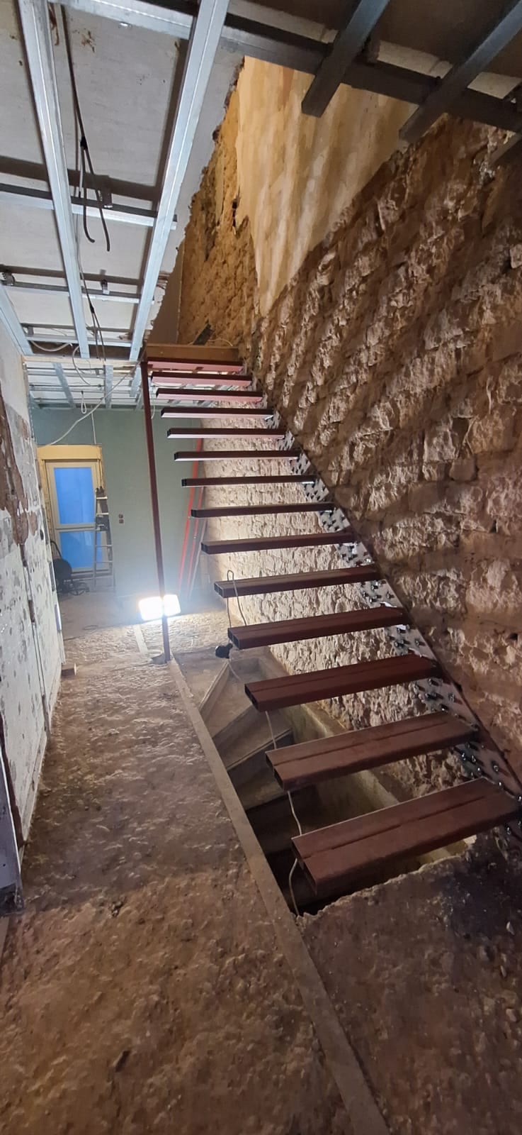Bestandstreppe im Altbau mit Natursteinwand vor dem Umbau – AN Treppenbau