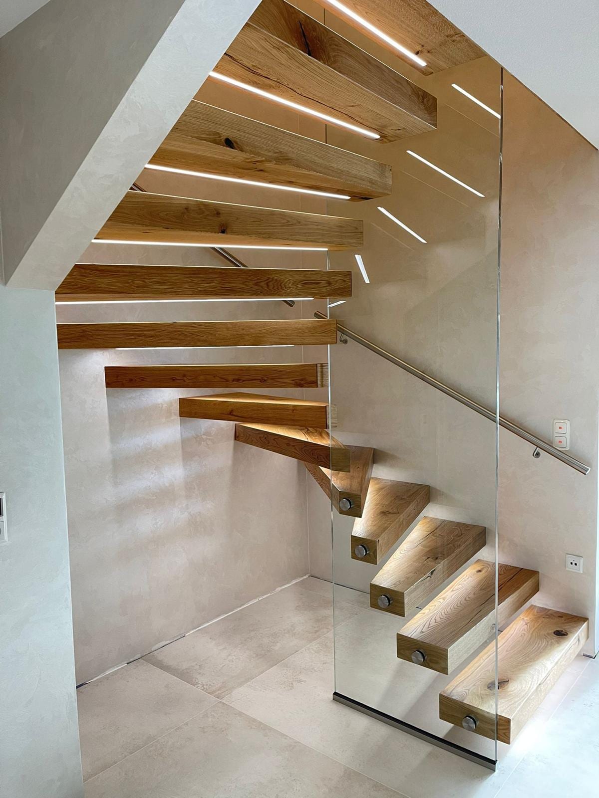 Kragarmtreppe in Eiche mit Lichtschlitz in der Stufenkante und Glasgeländer – AN Treppenbau