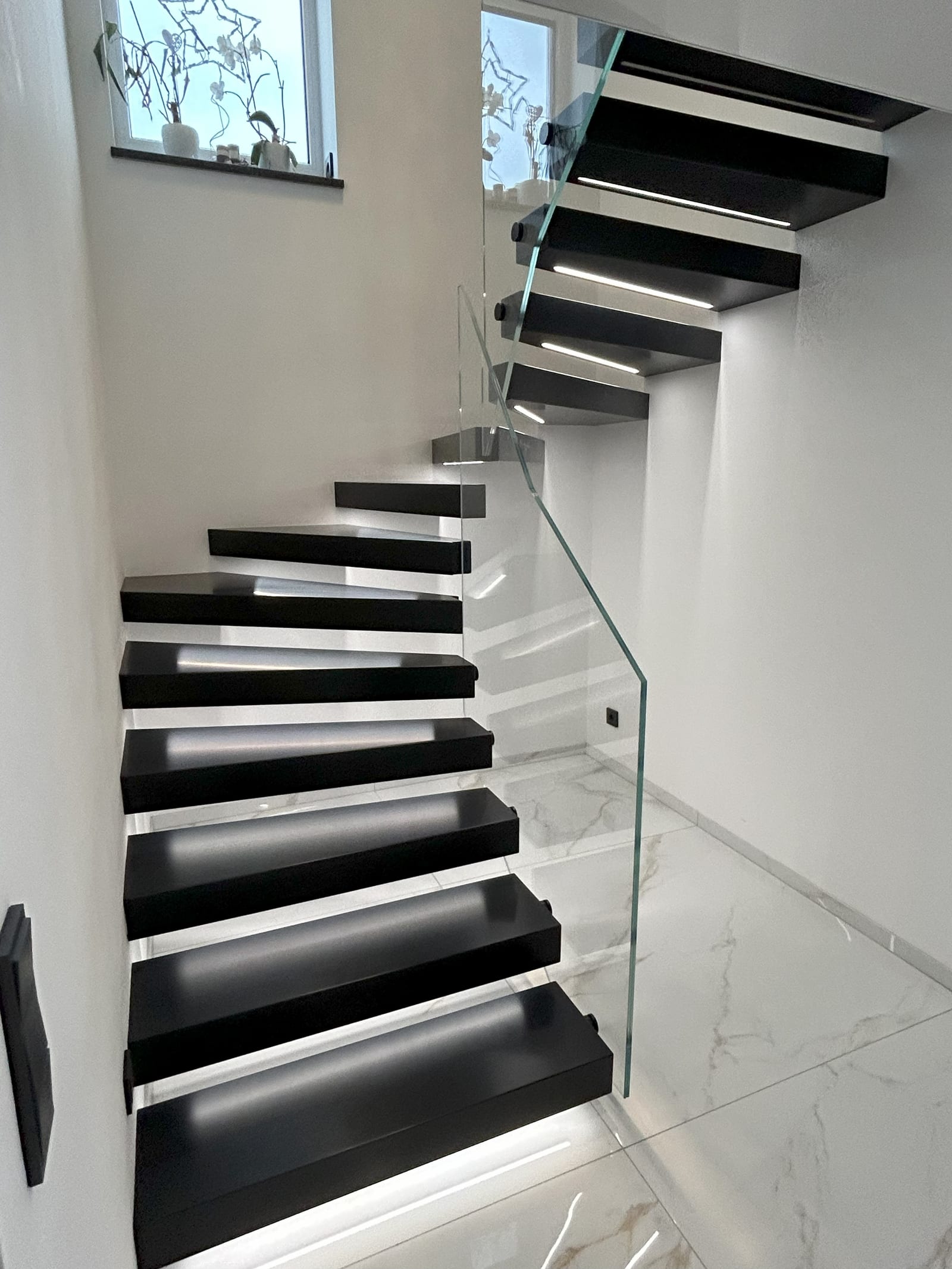 Kragarmtreppe mit dunklen Stufen und heller Unterlichtkante – AN Treppenbau